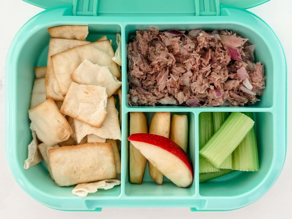 Kid's pink bento box with Zucchini Pizza Bites and a side of grapes and berries